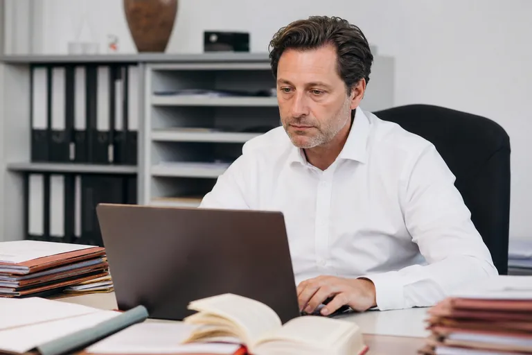 Rechtsanwalt prüft den Versandstatus eines Schriftsatzes am Laptop